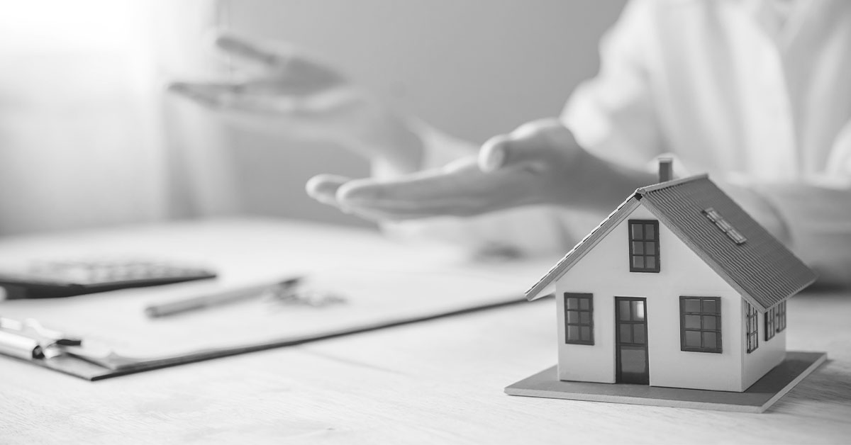 Miniature model of house; Person in background with hands spread