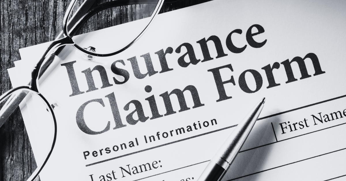 Insurance claim form close up with pen and eye glasses on table