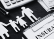 insurance policy form with icons of family holding hands representing insurance coverage on desk
