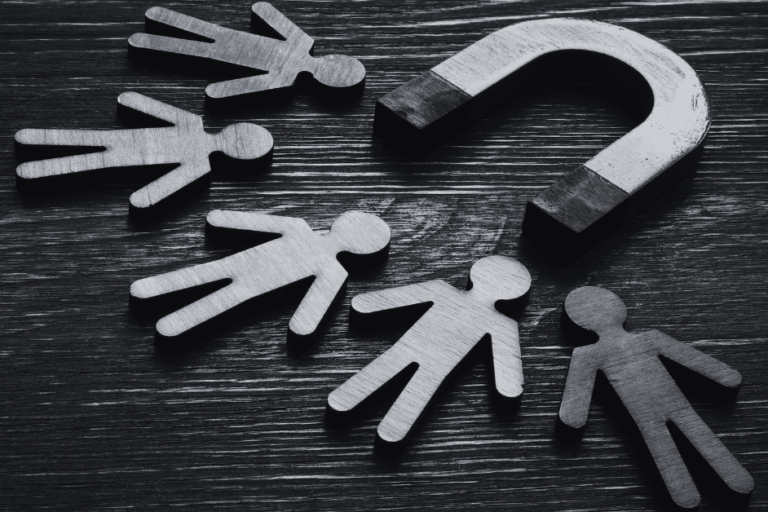 image of a magnet pulling in various person figures on a wood table