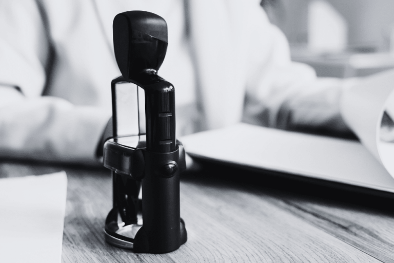 Insurance underwriter assessing application with stamp of approval in center